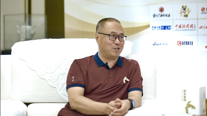 Wang Wei seated during his 2023 Guizhou Radio and Television interview